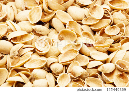 Macro shot of a pile of peeled pistachio nut shells. Organic background showing detail, natural beige color, and food waste texture. Concept of recycling, healthy snacking, and natural material 135449869