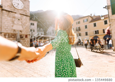 Follow me concept and traveling together. Girl traveler wearing dress, holds the boyfriend's hand 135449880