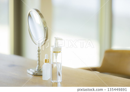 A woman looking in the mirror in the living room A woman looking in the mirror in the living room 135449891