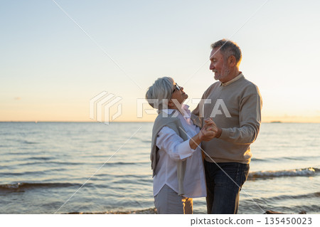Keep moving. Romantic senior mature couple dancing together on beach outdoor recreation. Happy smiling family retired man woman husband wife having fun enjoying time together. Family moment love care Keep moving. Romantic senior mature couple dancing together on beach outdoor recreation. Happy smiling family retired man woman husband wife having fun enjoying time together. Family moment love care 135450023