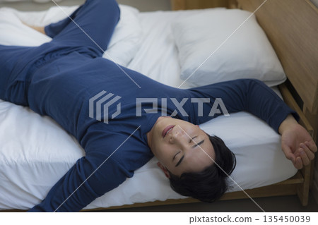 A man sleeping in bed 135450039