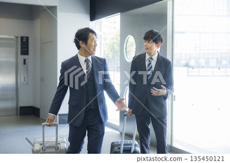商人在辦公大樓裡行走 商人在辦公大樓裡行走 135450121