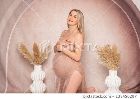 38 week, Artistic studio portrait of a pregnant woman posing nude with soft drapery. Elegant composition, calm mood and natural beauty. Concept of femininity, maternity and body positivity. 38 week, Artistic studio portrait of a pregnant woman posing nude with soft drapery. Elegant composition, calm mood and natural beauty. Concept of femininity, maternity and body positivity. 135450297