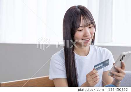 Young woman with smartphone and credit card Young woman with smartphone and credit card 135450532