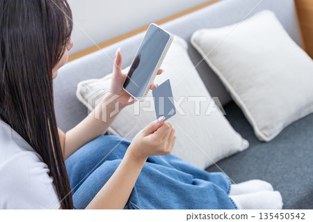 Young woman with smartphone and credit card Young woman with smartphone and credit card 135450542