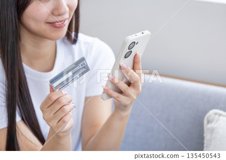 Young woman with smartphone and credit card 135450543