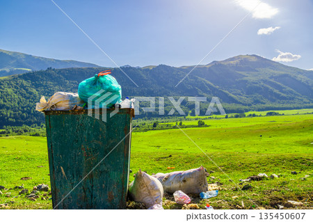Overflowing trash and recycling bin in rural landscape Overflowing trash and recycling bin in rural landscape 135450607