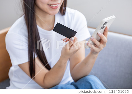 Young woman with smartphone and credit card Young woman with smartphone and credit card 135451035