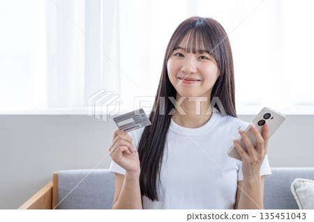 Young woman with smartphone and credit card Young woman with smartphone and credit card 135451043