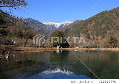Winter scenery of Komagaike Pond in Komagane City, Nagano Prefecture in December, overlooking the snow-capped Central Alps 135451170