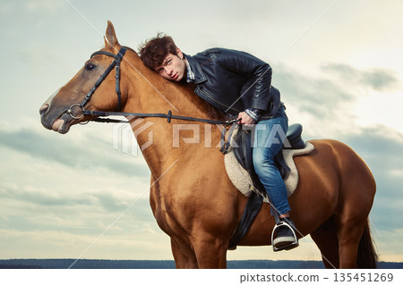 A man riding a horse outdoors A man riding a horse outdoors 135451269