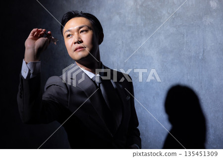 深色背景下的商人 深色背景下的商人 135451309