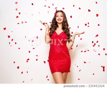 Woman in festive dress under confetti 135451324