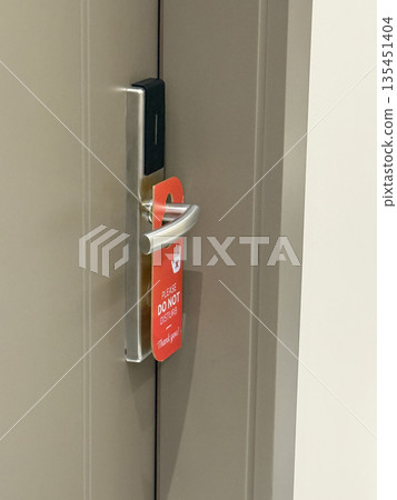Do not disturb door hanger on hotel room door indicating guest privacy background 135451404
