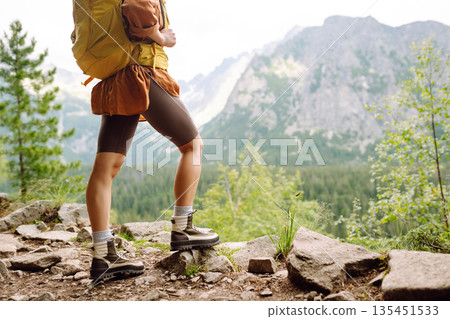 Close-up of female legs in hiking boots on a hiking trail. Travel, vacation. The concept of nature. Close-up of female legs in hiking boots on a hiking trail. Travel, vacation. The concept of nature. 135451533