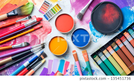 Colorful flat-lay features Pantone color samples, paint brushes, and various tools arranged for an art and design project. The scene captures creativity in action 135451736