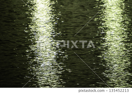 City lights reflected on the water surface and ripples 135452213