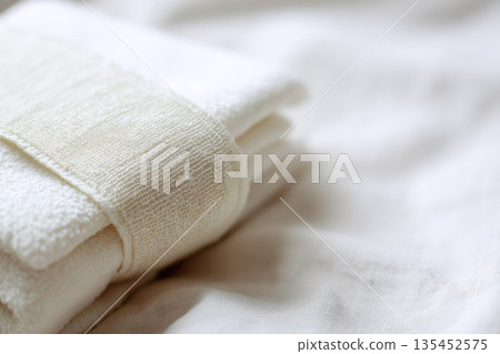 Soft postpartum care kit towel folded neatly on white fabric surface, providing comfort and gentle support for new mothers during recovery, creating calm and soothing atmosphere Soft postpartum care kit towel folded neatly on white fabric surface, providing comfort and gentle support for new mothers during recovery, creating calm and soothing atmosphere 135452575