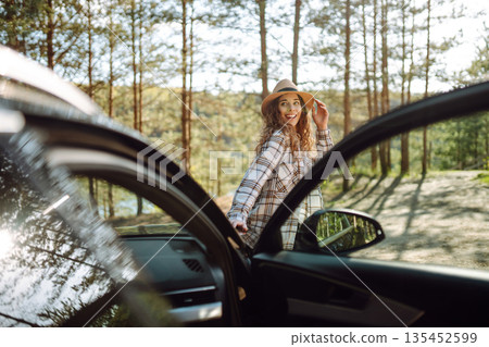 Young woman enjoying and having fun in their vacations outdoors leaning out car window. Summer trip. Young woman enjoying and having fun in their vacations outdoors leaning out car window. Summer trip. 135452599