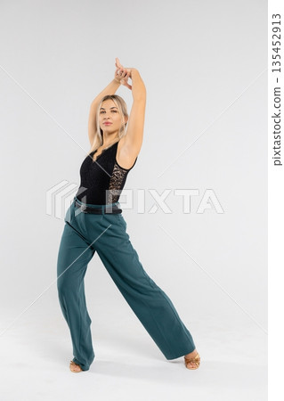 Professional dancer performing tango steps in studio with white background Professional dancer performing tango steps in studio with white background 135452913
