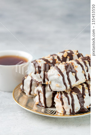 butter cookies dessert covered in chocolate and walnut glaze on gray table. 135453550