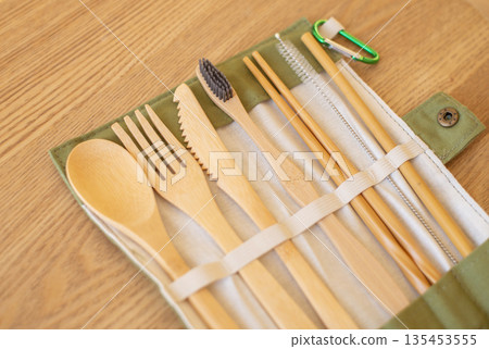 Set of Eco friendly bamboo cutlery on wood background. Sustainable lifestyle. Plastic free concept. Close-up, top view. Selective focus. Set of Eco friendly bamboo cutlery on wood background. Sustainable lifestyle. Plastic free concept. Close-up, top view. Selective focus. 135453555
