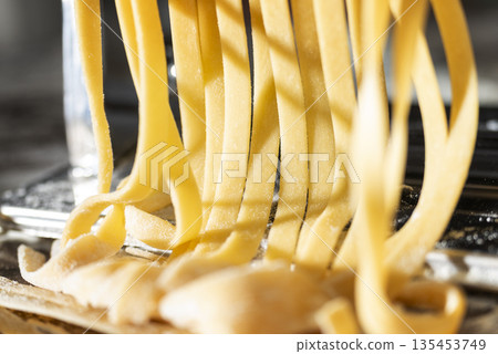 Fresh raw noodles made on home pasta machine closeup low angle view 135453749