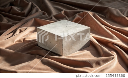 A concrete cube rests on flowing textured brown velvet fabric creating a minimalist composition A concrete cube rests on flowing textured brown velvet fabric creating a minimalist composition 135453868