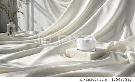 Elegant white cosmetic jar resting on flowing luxurious silk drapery 135453883