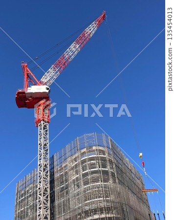 正在興建中的建築物和高聳入雲的塔吊在藍天下格外醒目(城市發展和重建的景象) 正在興建中的建築物和高聳入雲的塔吊在藍天下格外醒目(城市發展和重建的景象) 135454013