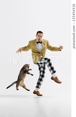 Man dancing with cat isolated on white background collage. Man dancing with cat isolated on white background collage. 135454316