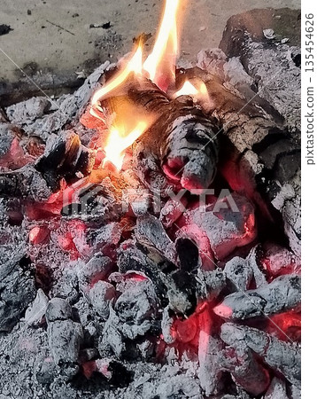 Close Up of Glowing Embers and Burning Wood Firewood in Outdoor Fire Pit 135454626
