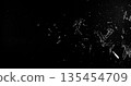 Side angle photo of flying shattered glass shards and dust isolated on black background. High detail debris explosion, perfect for VFX overlay, compositing, transitions or dramatic design elements. 135454709