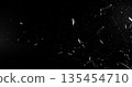 Side angle photo of flying shattered glass shards and dust isolated on black background. High detail debris explosion, perfect for VFX overlay, compositing, transitions or dramatic design elements. 135454710