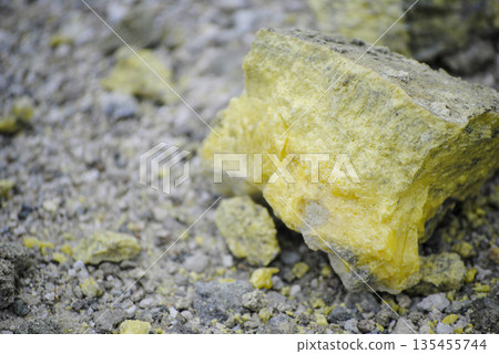 Macro shot of vibrant yellow sulfur crystals on a fumarole field. Natural mineral deposits on the slopes of Kuril Islands. Macro shot of vibrant yellow sulfur crystals on a fumarole field. Natural mineral deposits on the slopes of Kuril Islands. 135455744