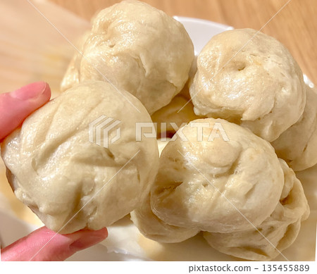 Picking up stacks of mini steamed buns Picking up stacks of mini steamed buns 135455889