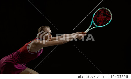 Female tennis player lunging for shot with dynamic motion Female tennis player lunging for shot with dynamic motion 135455896