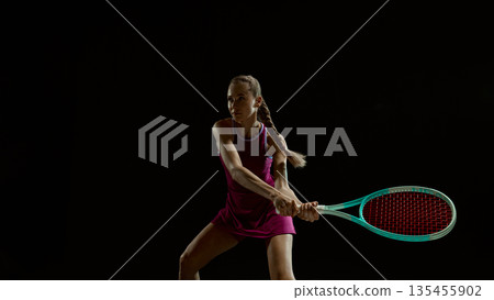 Female tennis athlete backhand stroke in studio lighting. Female tennis athlete backhand stroke in studio lighting. 135455902