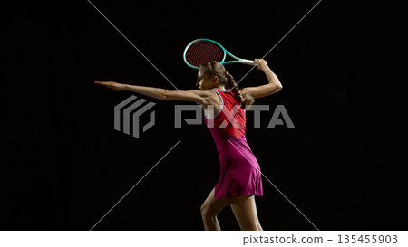Female tennis player powerful serve motion on dark background. Female tennis player powerful serve motion on dark background. 135455903