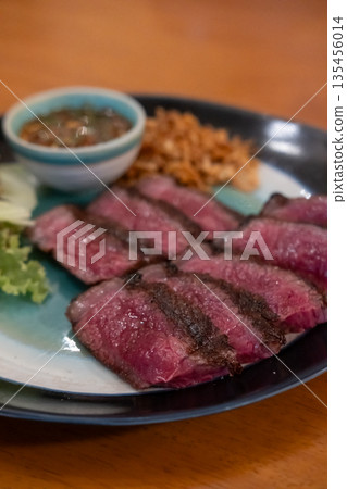 Medium rare sliced Picanha steak meat served on plate with vegetable 135456014