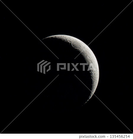 Crescent Moon Against Black Sky with Lunar Surface Details 135456254