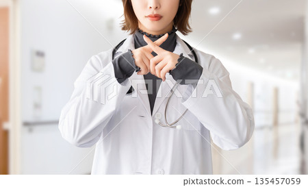 一名女性醫護人員用手指擺出「X」型姿勢 一名女性醫護人員用手指擺出「X」型姿勢 135457059