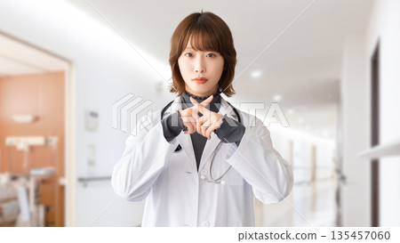 一名女性醫護人員用手指擺出「X」型姿勢 一名女性醫護人員用手指擺出「X」型姿勢 135457060