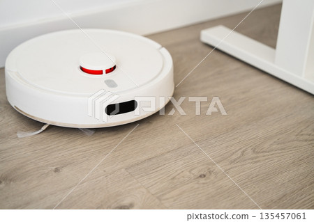Autonomous robot vacuum cleaning hardwood floor in contemporary apartment, smart home appliance and automation concept Autonomous robot vacuum cleaning hardwood floor in contemporary apartment, smart home appliance and automation concept 135457061