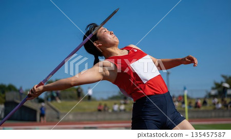 一名高中女運動員在標槍比賽中展現了她強勁的投擲姿勢。 一名高中女運動員在標槍比賽中展現了她強勁的投擲姿勢。 135457587