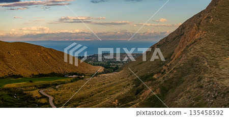 Winding road through serene mountainous landscape at sunset 135458592