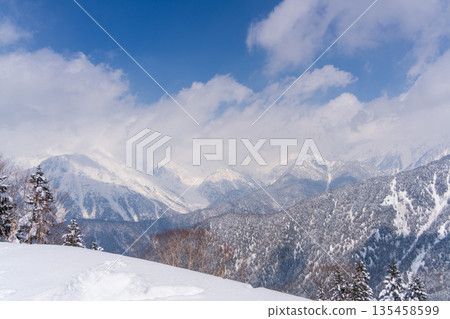 Winter new rice harvest Snow-covered mountain range scenery Winter new rice harvest Snow-covered mountain range scenery 135458599
