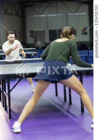 People playing energetic table tennis indoors People playing energetic table tennis indoors 135458781