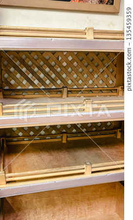 Empty wooden shelves with lattice backing for bakery display or rustic retail product placement. 135459359