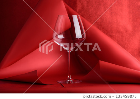 Wine Glass for Red Wine on Sculptural Red Background. Artistic Still Life with Transparency and Form Wine Glass for Red Wine on Sculptural Red Background. Artistic Still Life with Transparency and Form 135459873